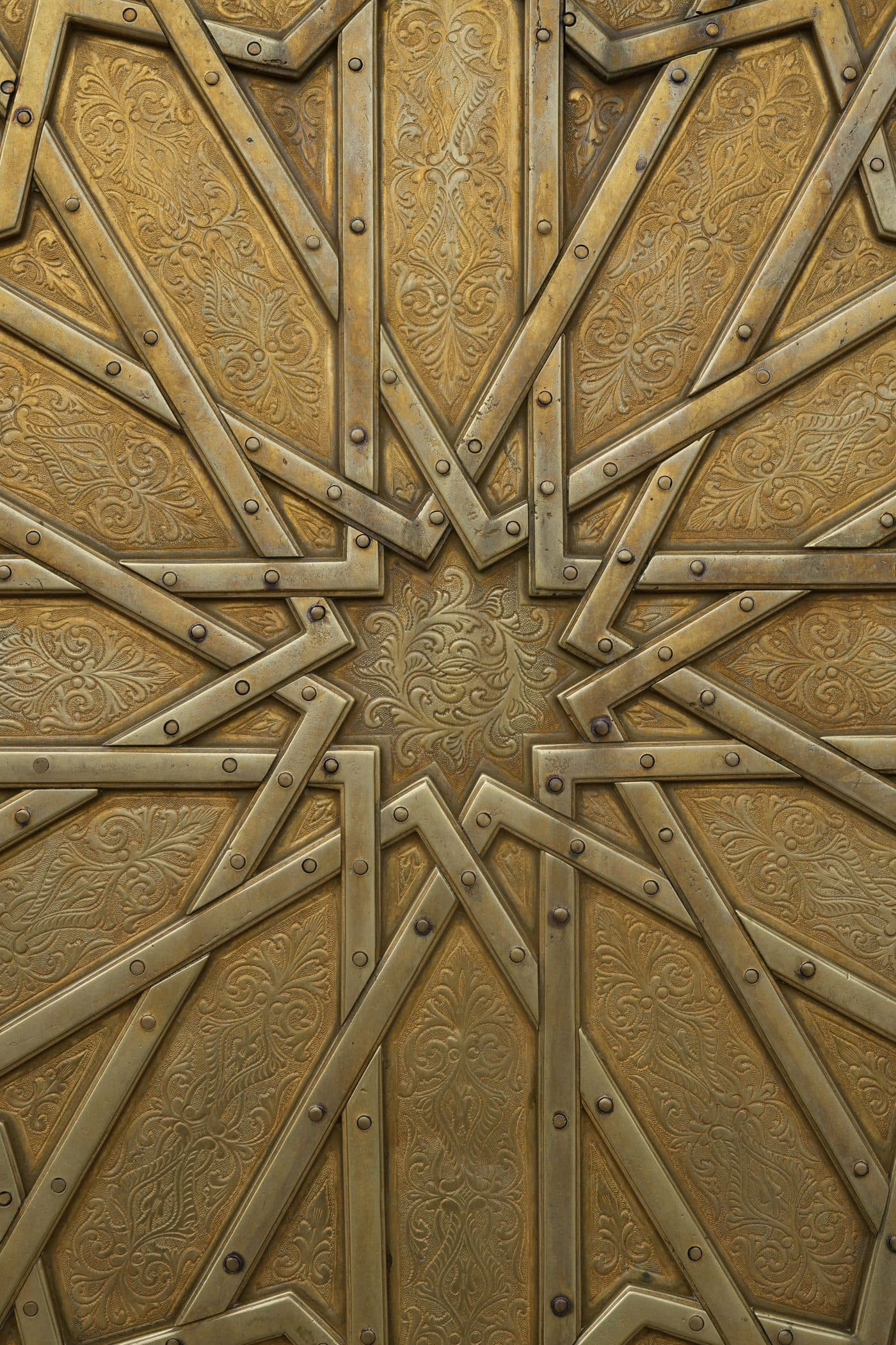 A brass door faced in a riveted star pattern.